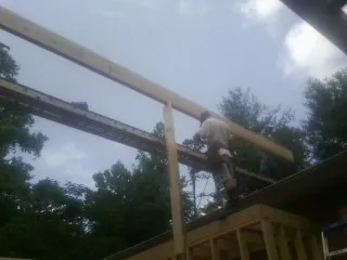 Carpenter setting a ridge beam over a new addition frame — Ice Dam Removal by Roofing Brothers in Elizabeth City