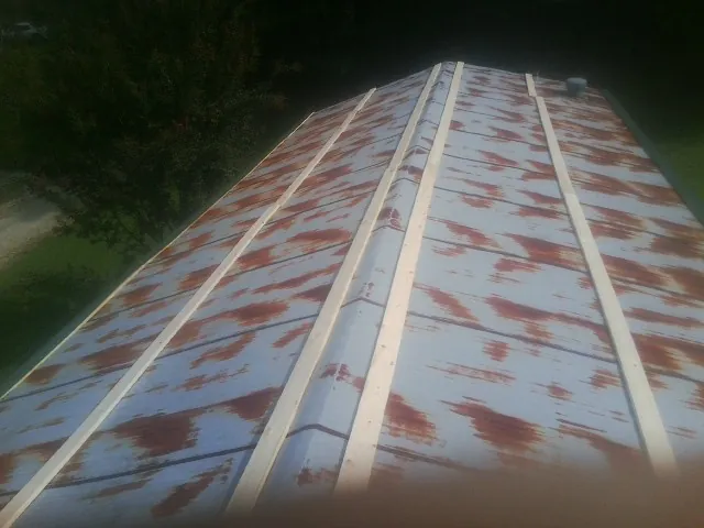 Rusted metal roof panels with new wood purlins before replacement — Storm Damage Roof Repair in Elizabeth City by Roofing Brothers