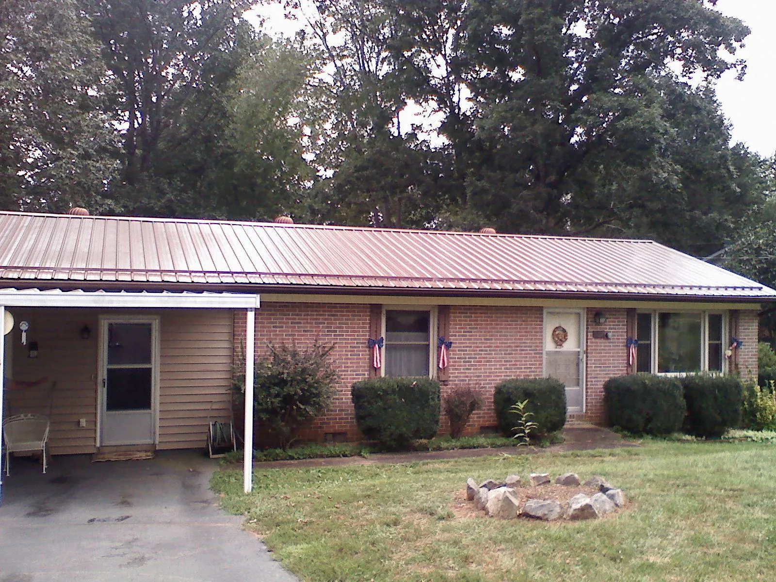 Bronze metal roof and carport on a brick ranch home — Roof Repair work by our crew in Elizabeth City